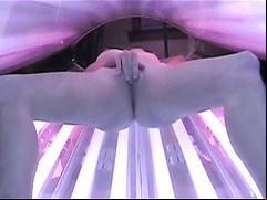 Petite blonde girl caught masturbating in the tanning bed